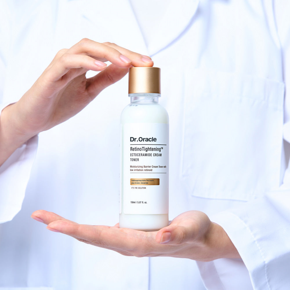 Dr. Oracle skincare bottle held by a hand against a light background
